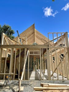 Framing picture of new barn being built, looking east