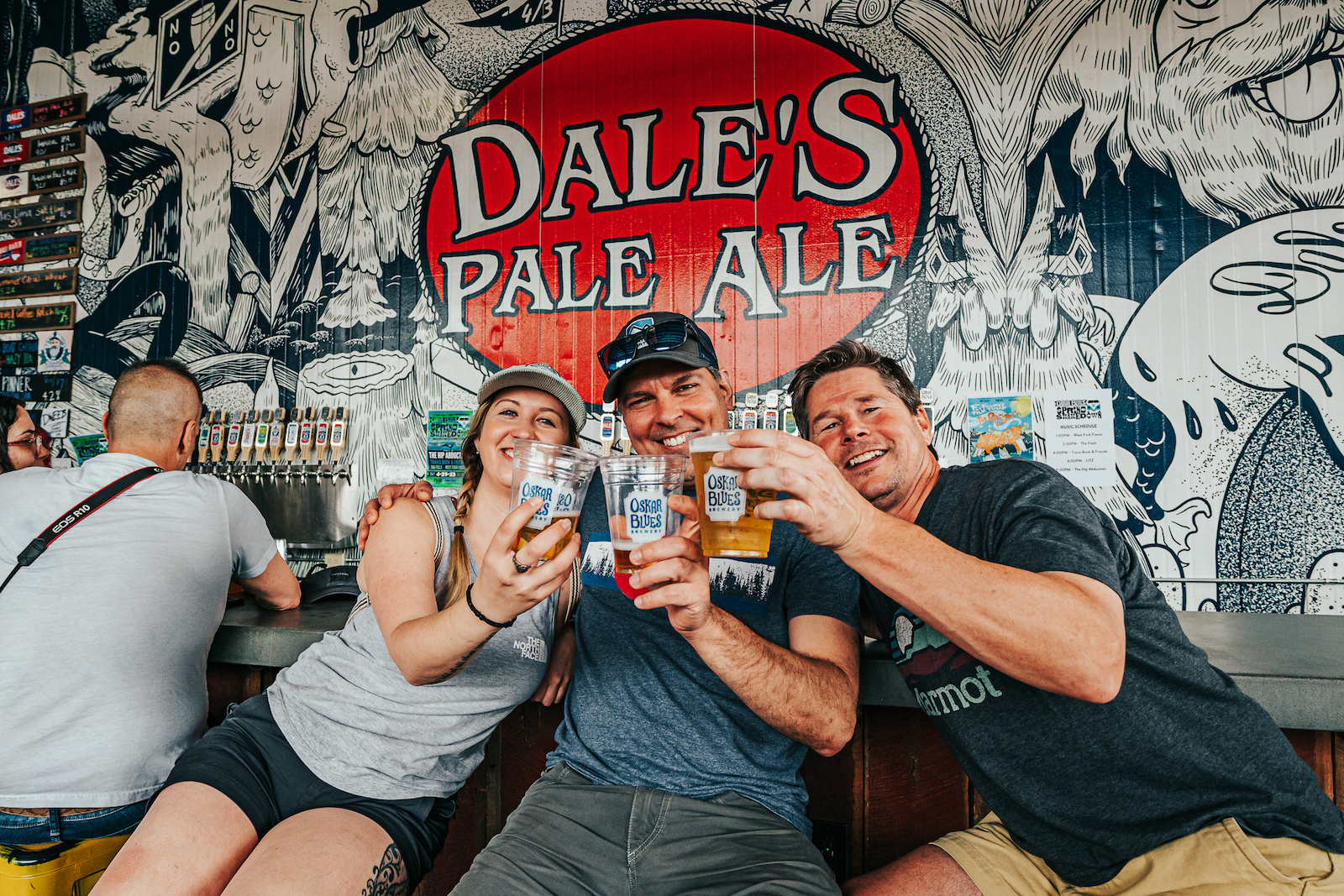 three people drinking beer at NC taproom
