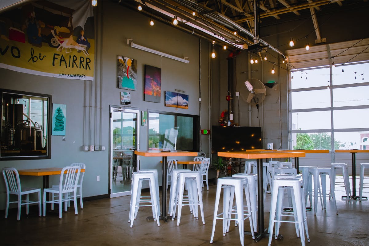 ogtaproom Pondaseta taproom with wooden tables and white stools