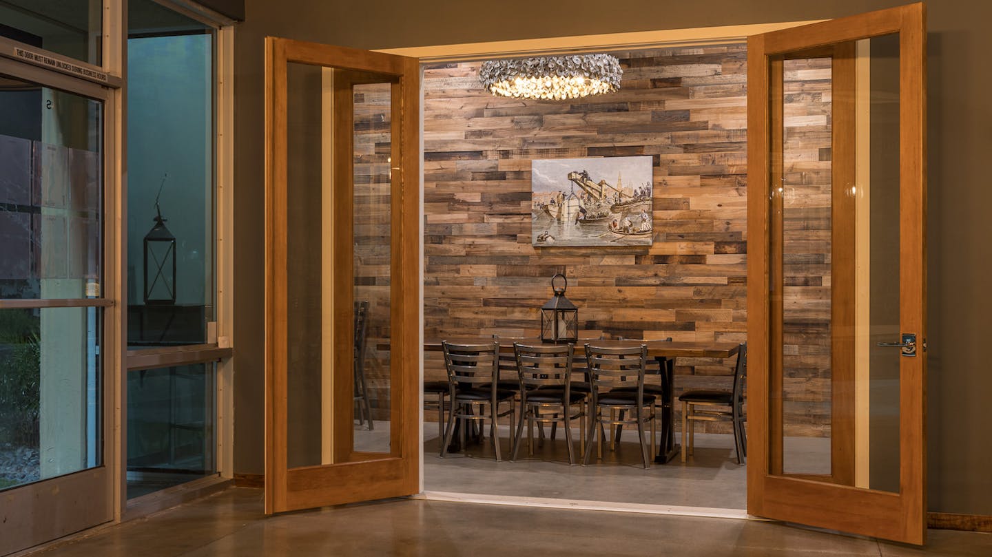 A private vent space with large wooden doors and a table and chairs inside