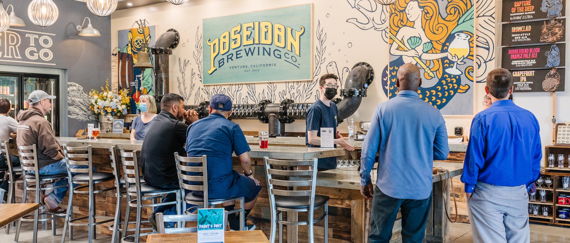 A taproom with patrons ordering and enjoying beer