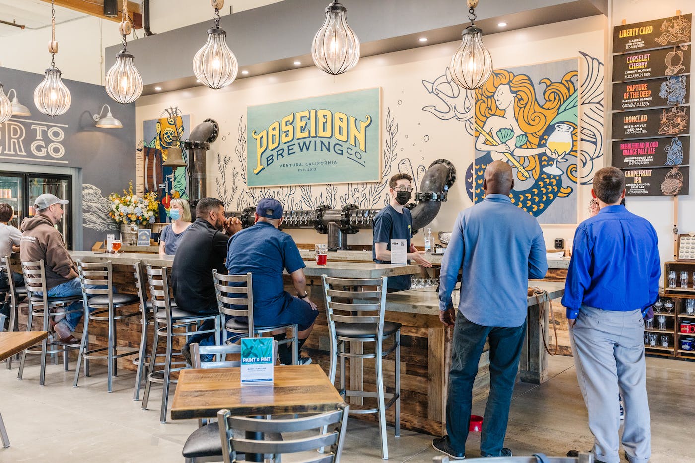 MainTaproomPeople-1 A taproom with patrons ordering and enjoying beer