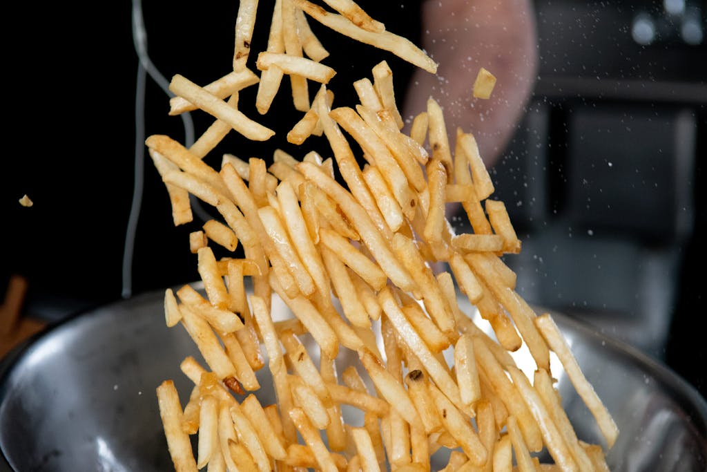 Fries being seasoned