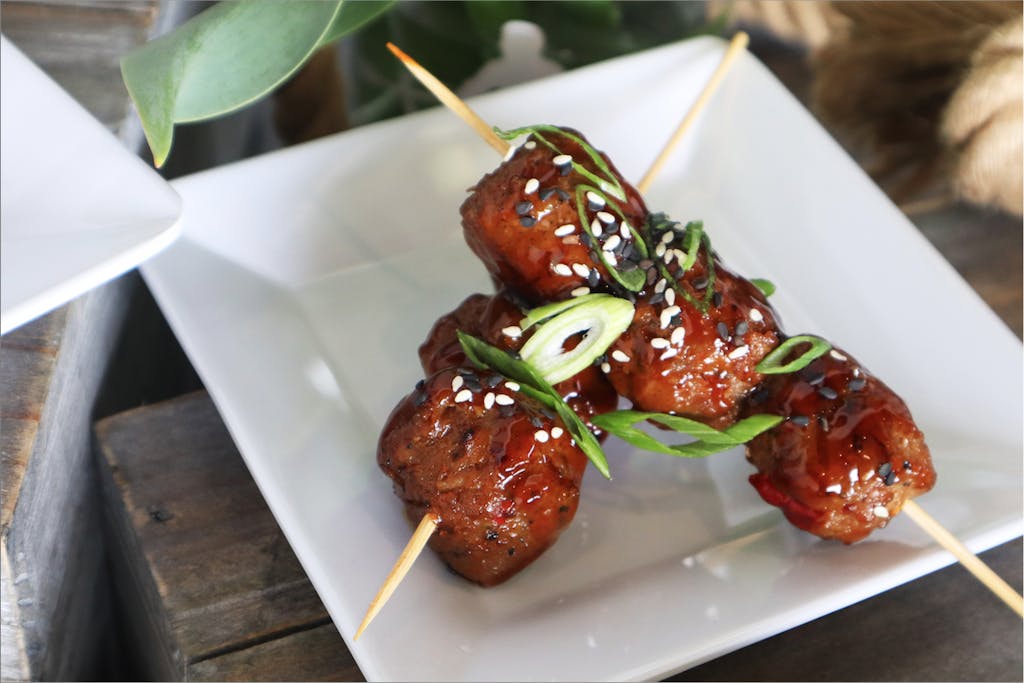 The Galley at Rising Tide Meatball Appetizer Two skewers of meatballs on a white plate