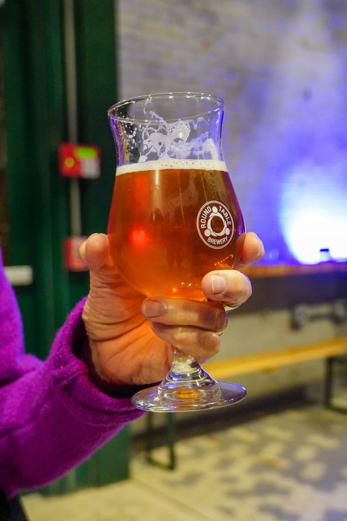 A close up of a customer holding a glass of Dr. Jay beer in the brewhouse at the Soft Opening event.
