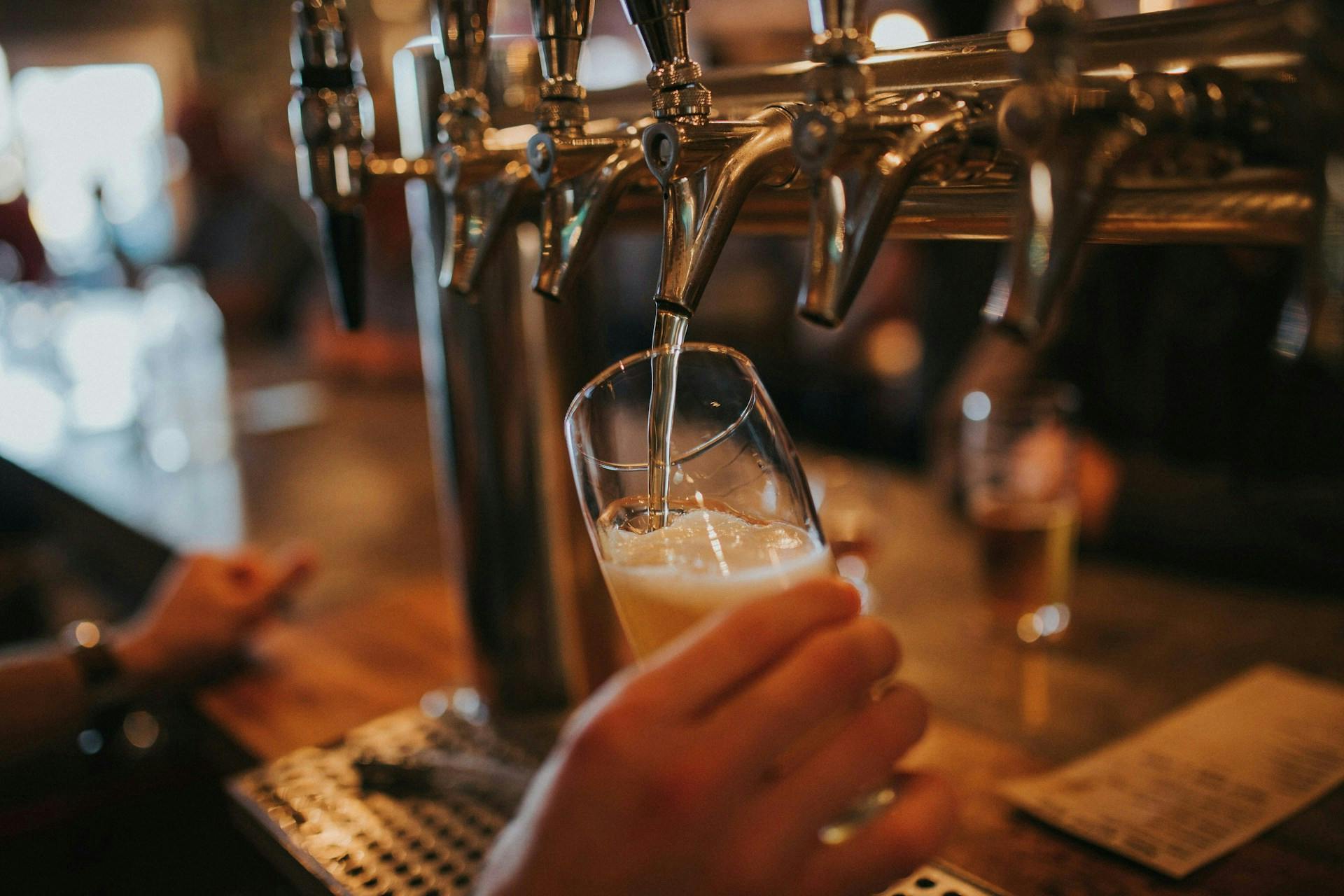 Beer is poured into a glass from a tap