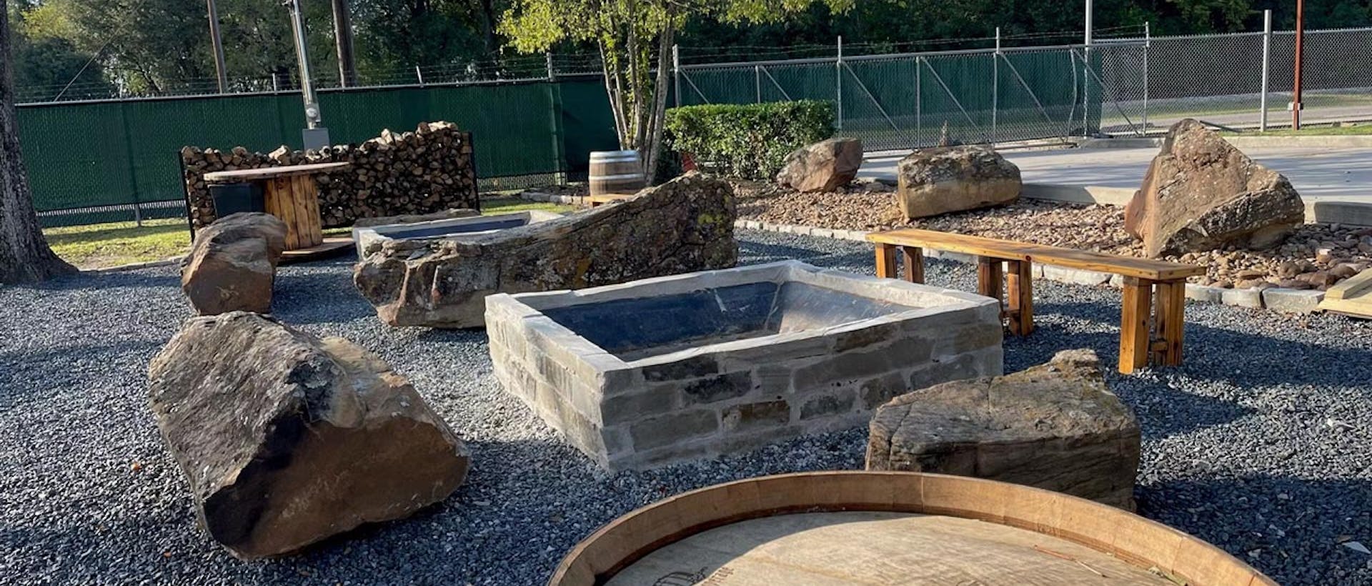 Outside Fire pit from SpindleTap Brewery. With some wooded benches, wood, and rocks for aesthetics.