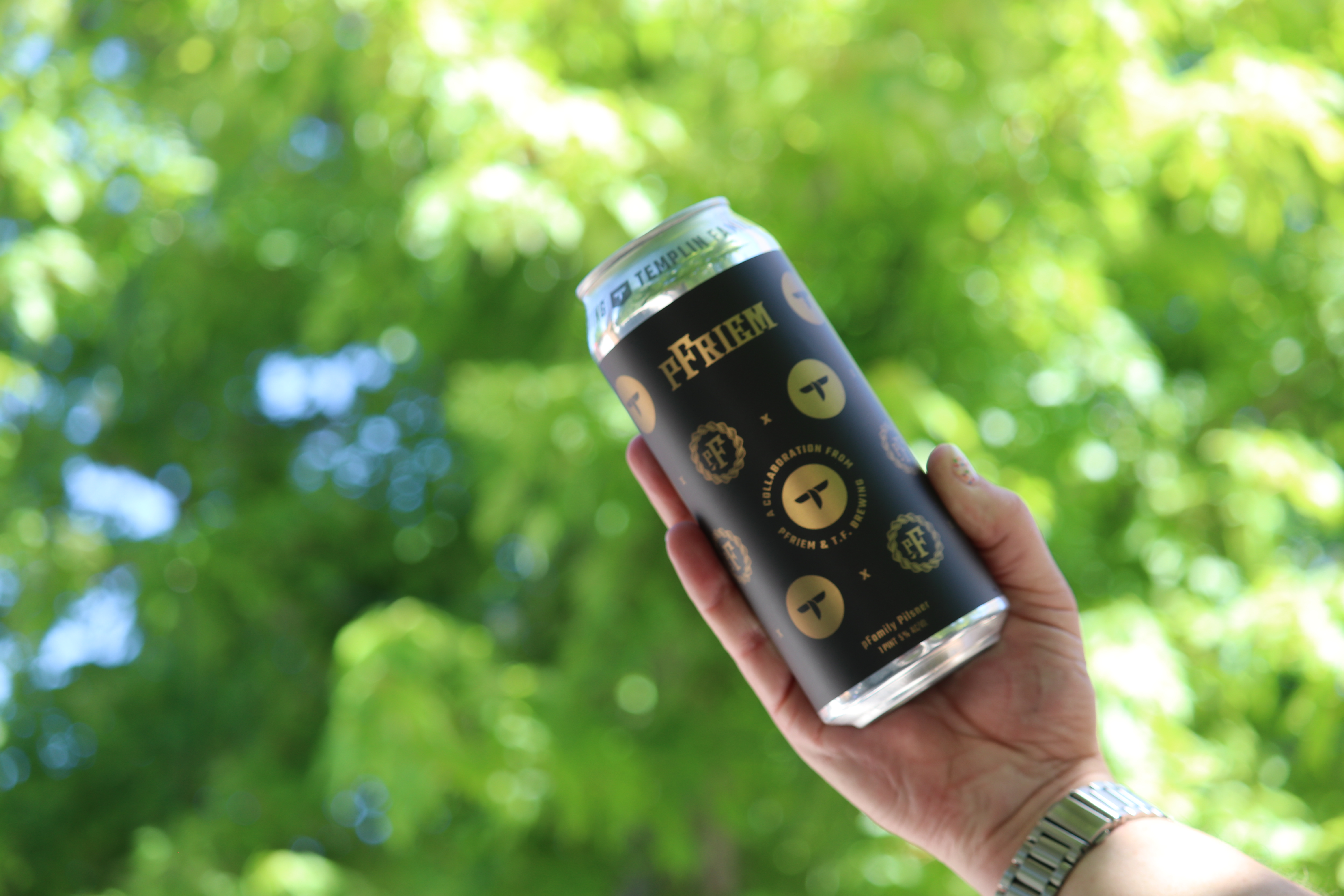 a collaboration beer can with green trees in the background!!