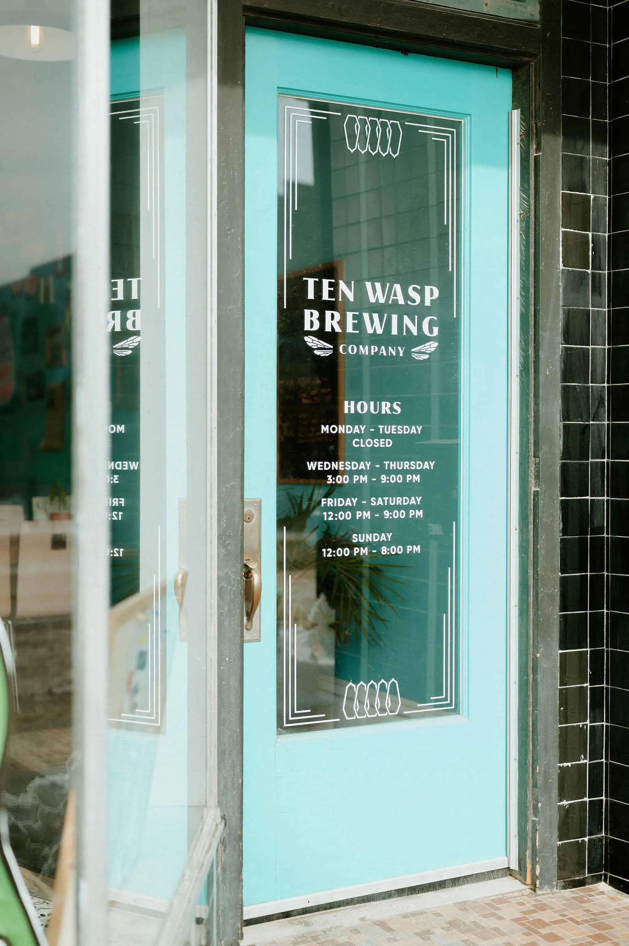 teal front door of Ten Wasp Brewing