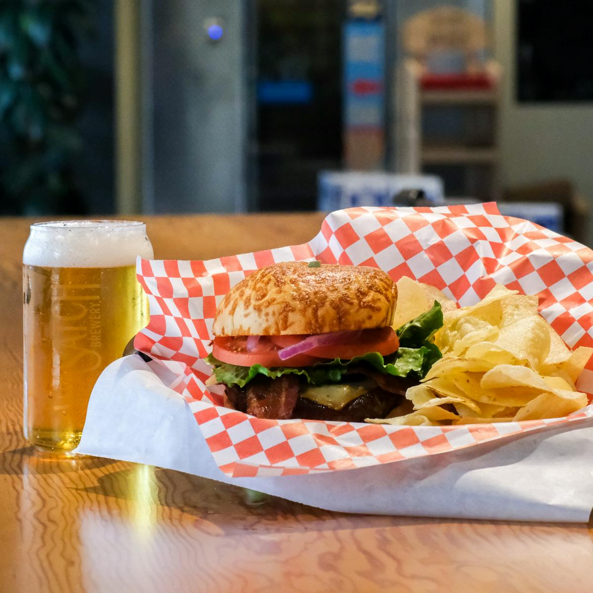 burger and chips next to a beer in the taproom and beer store