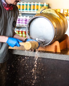 Male Brewer Tapping Firkin