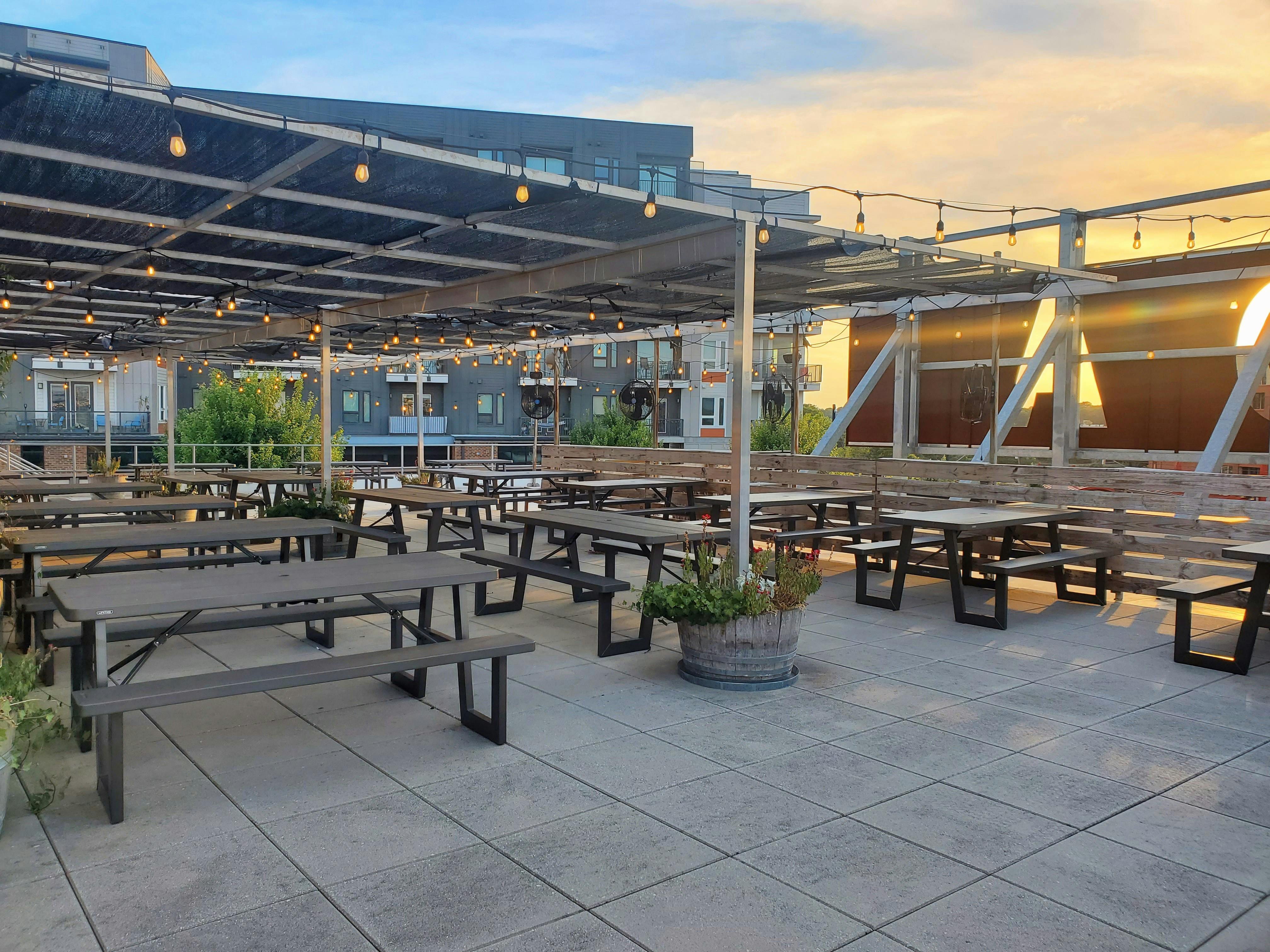Chamber - Rooftop Rooftop patio at sunset that is partially covered and has 20 picnic tables